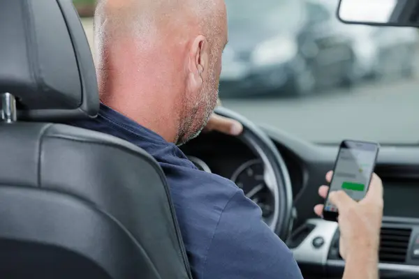 Man uses his phone while driving